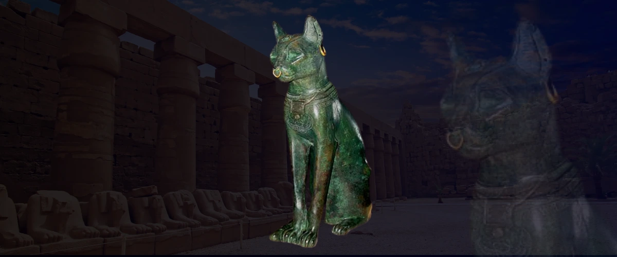 Bronze statue of a seated cat with earrings and a necklace, showcasing the elegance of cats in art against an ancient stone temple background.